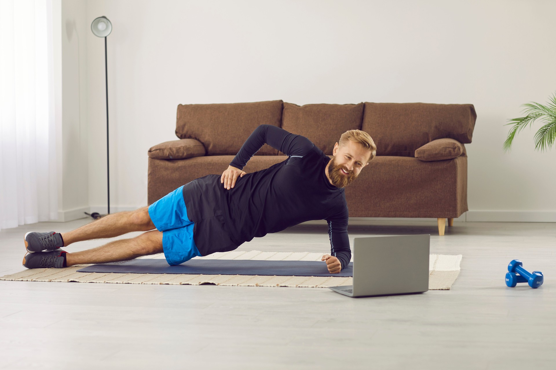 Sporty man train online using computer gadget